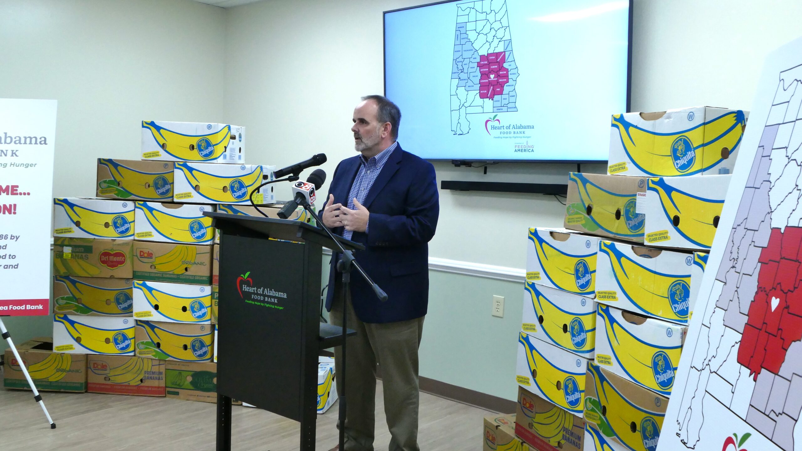 a man standing at a podium with microphones